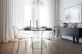 a bright and airy dining room with a mix of modern and traditional furniture, including a glass table and metal chairs