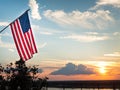 Bright american flag flying above beautiful sunset over Mississippi river Royalty Free Stock Photo
