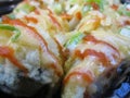 Bright attractive crispy Japanese sushi rolls with tasty sauce close up