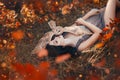 Bright autumn art photo, goddess rests in autumn orange forest under protection of cute little owl, girl with dark hair