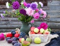 Bright autumn asters in a bouquet on a wooden background with vegetables and fruits on the table, side view, close-up Royalty Free Stock Photo