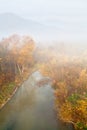 Trees with yellow foliage over the river in fog, foggy mountains on the4 horizon. Ukraine. Royalty Free Stock Photo