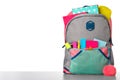 Bright backpack with school stationery on stone table against white background Royalty Free Stock Photo