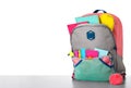 Bright backpack with school stationery on stone table against white background Royalty Free Stock Photo