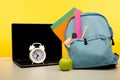 Bright backpack with supplies and laptop on a table. Online education theme Royalty Free Stock Photo
