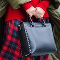 A bright bag in women`s hands. Leather bag.