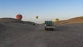 Bright balloons rise into the clear blue sky above the desert hills.