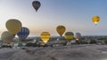 Bright balloons rise in the dawn sky over the desert in Luxor. Royalty Free Stock Photo