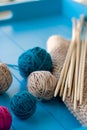 Bright balls of yarn, wooden knitting needles, knitted blanket