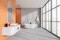 Bright bathroom interior with sink and tub near panoramic window Royalty Free Stock Photo
