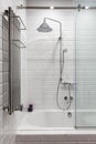 Bright bathroom with new tiles. Chrome shower, faucet, white bathroom.