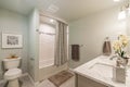 Bright Bathroom Shower and Sink white walls and gray tile flooring