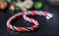 Bright beaded necklace red, black and white colors on a dark background Royalty Free Stock Photo