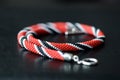 Bright beaded necklace red, black and white colors on a dark background Royalty Free Stock Photo