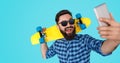 Bright bearded guy taking selfie with skateboard Royalty Free Stock Photo