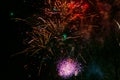 Bright and beautiful festive fireworks, red-yellow and pink colors, with haze, in the night sky Royalty Free Stock Photo