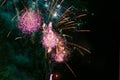 Bright and beautiful festive fireworks, red-yellow and pink colors, with haze, in the night sky Royalty Free Stock Photo