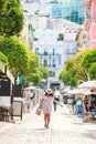 a bright beautiful girl in a light dress and hat walks along the streets of Monaco in sunny weather in the summer, a Royalty Free Stock Photo