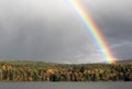 Bright, Beautiful Rainbow over the Trees and Lake Royalty Free Stock Photo