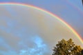Bright beautiful real double rainbow in cloudy sky