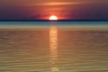 Bright beautiful sunset at the calm sea. Solar disk over water. Royalty Free Stock Photo