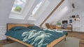 Bright bedroom in attic with bed and home office Royalty Free Stock Photo