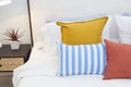 Bright bedroom interior with striped pillow on bed and bedside table lamp Royalty Free Stock Photo