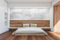 Bright bedroom interior with white marble wall, large bed Royalty Free Stock Photo