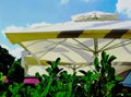 cream color light canvas awning or parasol with green terrace and blue sky