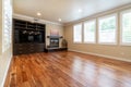 Bright beige large empty room with wood floor, molding and windows. Royalty Free Stock Photo