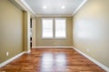 Bright beige large empty room with wood floor, molding and windows. Royalty Free Stock Photo