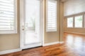 Bright beige large empty room with wood floor, molding and windows. Royalty Free Stock Photo