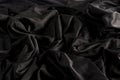 Bright black fabric with ripples and texture with hard light and dark light