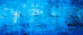 Bright blue abstract wall with textured, organic landscapes. Monochromatic depth, distressed surfaces