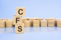 on a bright blue background, light wooden blocks and cubes with the text CFS Royalty Free Stock Photo