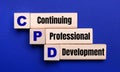 On a bright blue background, light wooden blocks and cubes with the text CPD Continuing Professional Development Royalty Free Stock Photo