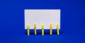 On bright blue background on yellow clothespins white blank card with copy space Royalty Free Stock Photo