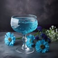 Bright blue cocktail in a nick and crystal glass garnished with a flower