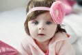 Bright blue eyed beauity 6 month old baby girl looks closely at the camera Royalty Free Stock Photo