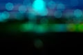 Bokeh - translucent blue and green hexagon and circular shapes emerging from a dark sky.