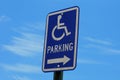 Bright blue handicapped parking sign against blue sky