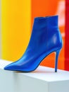 Bright blue high heel ankle boot on white podium.