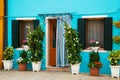 Bright blue house on Burano island, Venice, Italy. Picturesque colorful wooden old style door and windows with green Royalty Free Stock Photo