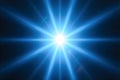Bright blue light emanating from the center of a dark background, creating a starburst effect with multiple radiating beams Royalty Free Stock Photo