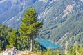 Bright blue mountain lake under blue sky with woods, stones and snow Royalty Free Stock Photo