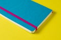 Bright blue notebook on a yellow background close up. Concept of finding ideas and inspiration for personal notes