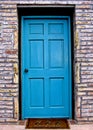 Bright blue, painted door is on a pale red brick building Royalty Free Stock Photo