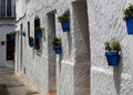 Bright blue plant-pots with Geraniums on white-washed houses, Spain Royalty Free Stock Photo