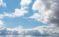 Bright blue sky with fluffy white clouds on a sunny day.