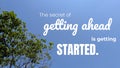 A bright blue sky and a green tree with a quote in white text. The quote reads, The secret of getting ahead is getting Royalty Free Stock Photo
